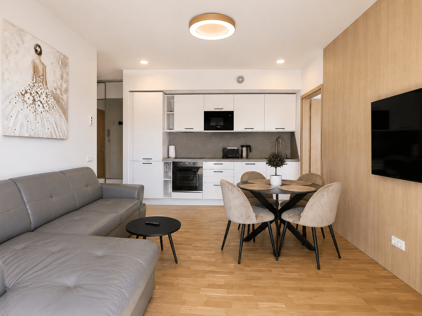 Jauki svetainės ir virtuvės zona moderniuose apartamentuose