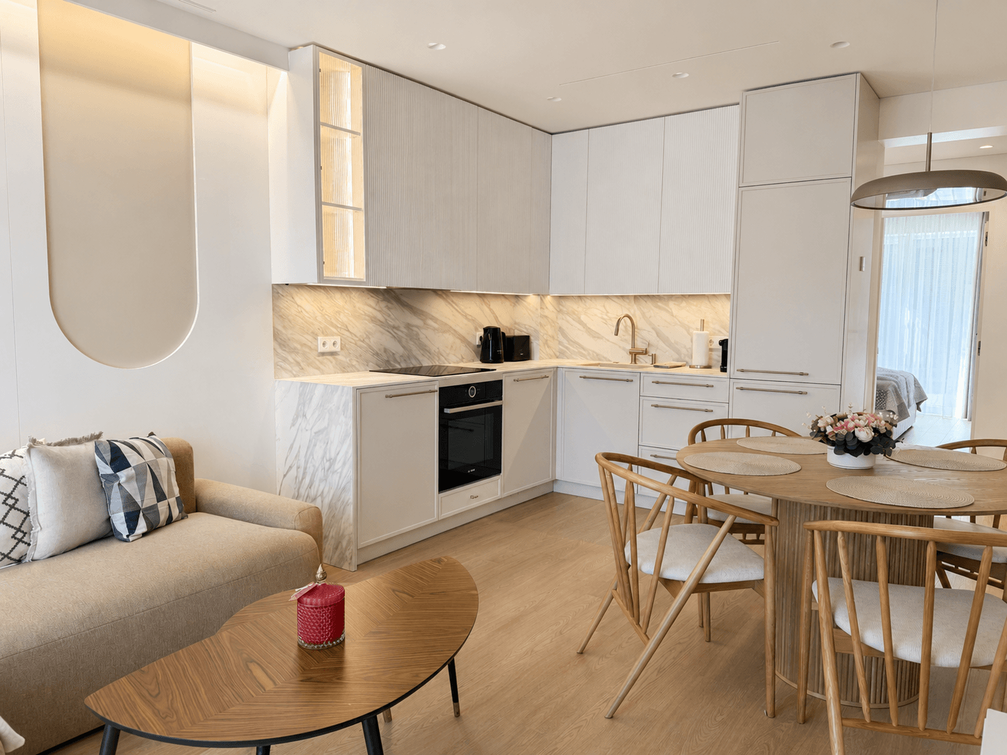 Jauki svetainės ir virtuvės zona moderniuose apartamentuose